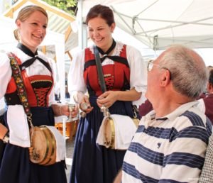A tourist share a laugh with schnapps servers from Rinn.