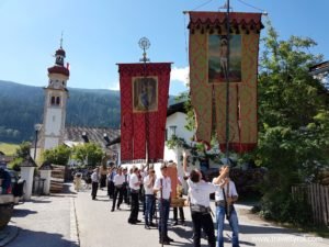 Fronleichnam procession participant outside church in Tulfes.